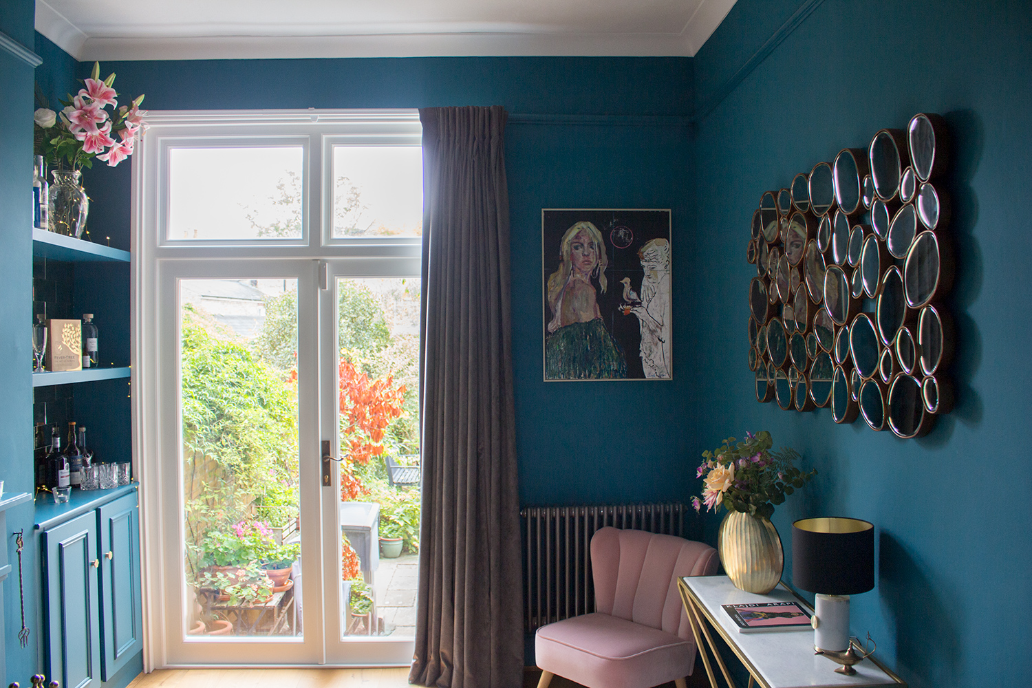 A photo of a living room painted in a blue with a strong green undertone, to keep it warm
