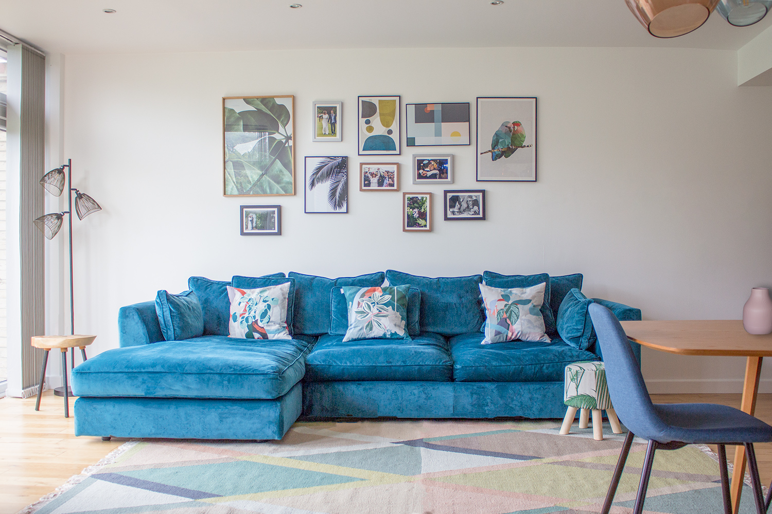 A photo of a velvet teal sofa in a living area.