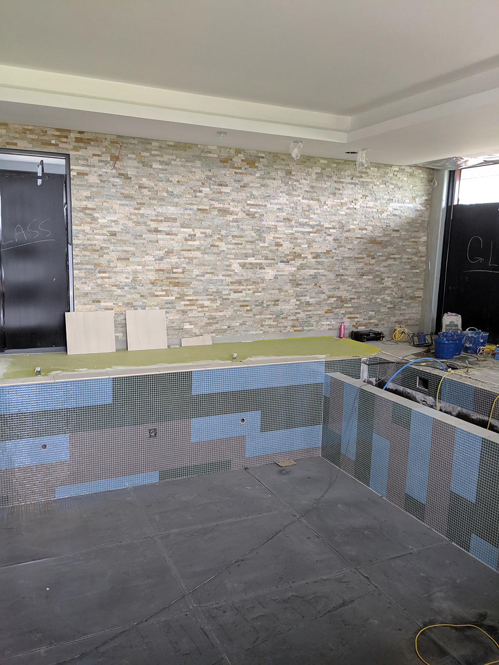 A photo showing the split face tile on the wall, with the pool and floor tiles with it.