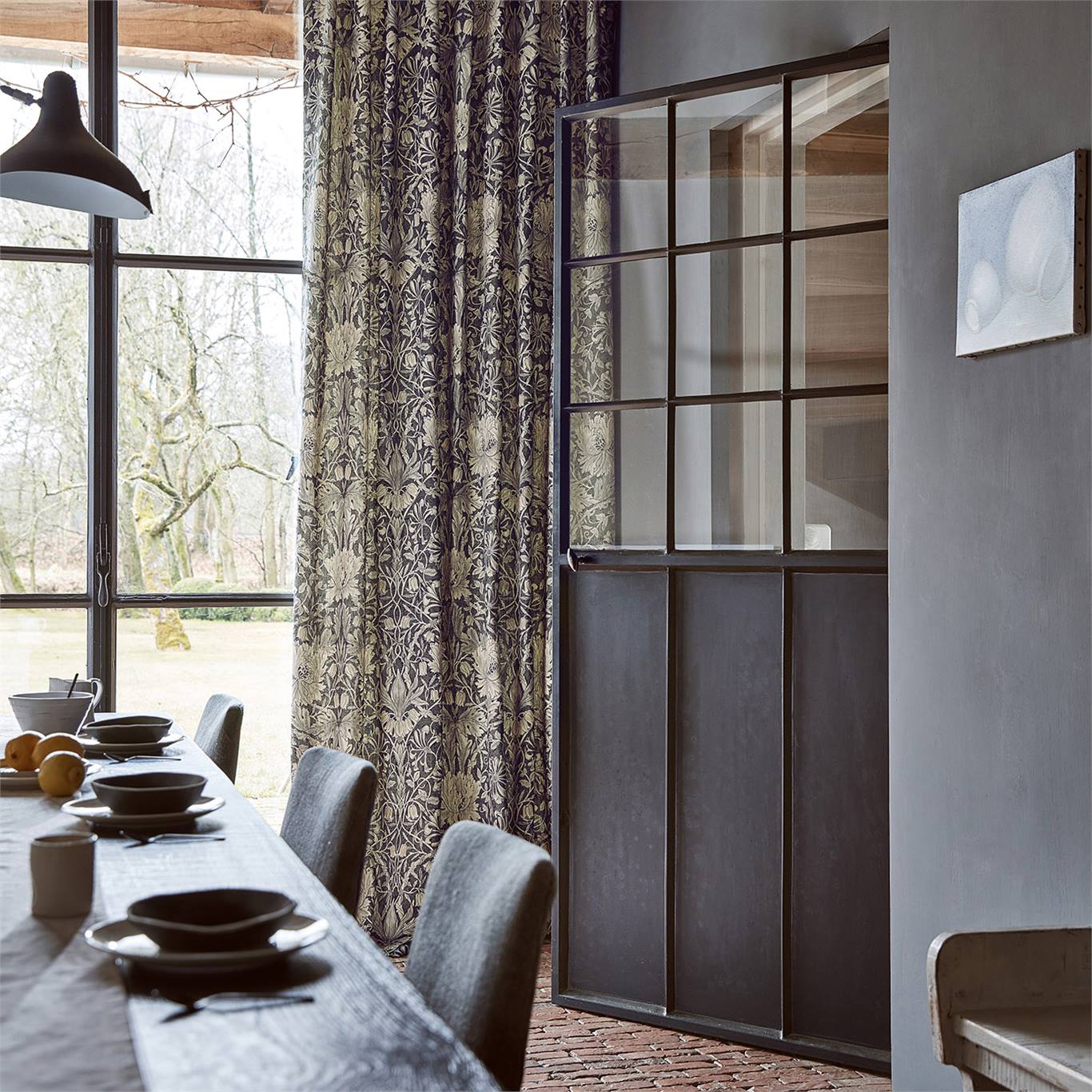 a darker fabric design made in to curtains, framing crittall style windows