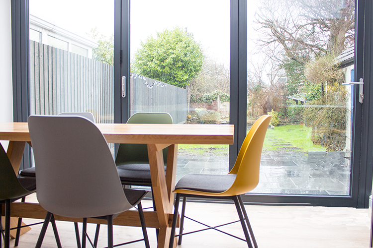 A photo of the new dining chairs in front of the new charcoal grey bi-fold doors.