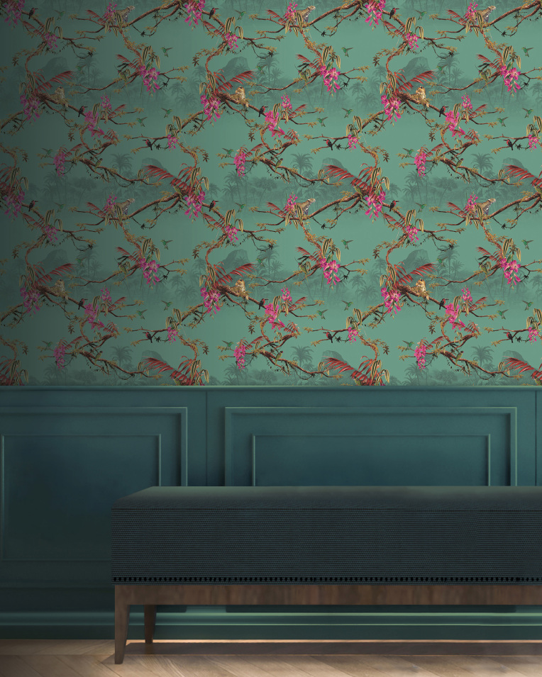 A tropical teal wallpaper plasters the wall above a wainscoting panelling and a navy fabric covered bench. The wallpaper is adorned with tropical wildlife and atmospheric jungle scenery including parrots and  jaguars. 