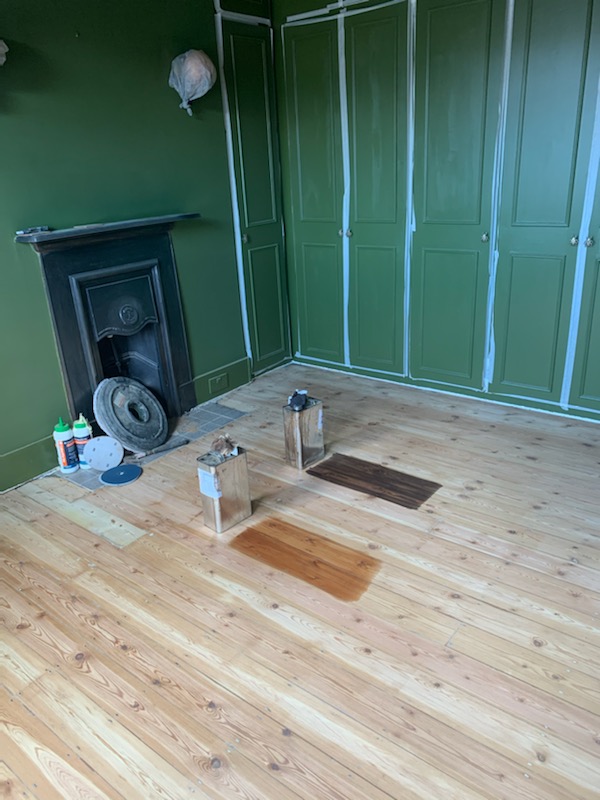 A photo of the sanded floorboards with two varnish colour options