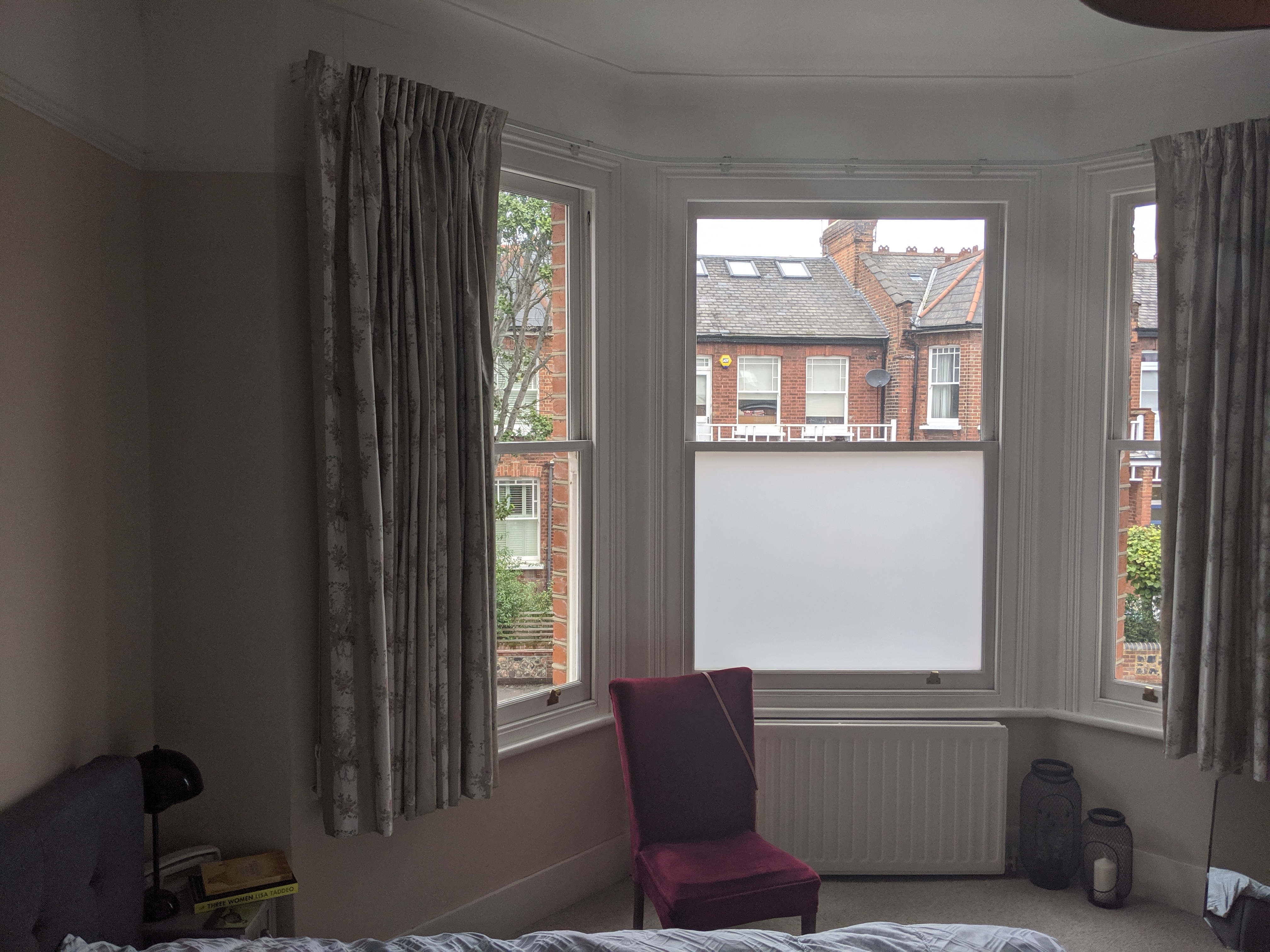 A before photo of the room, showing the peach walls and floral curtains at the window.