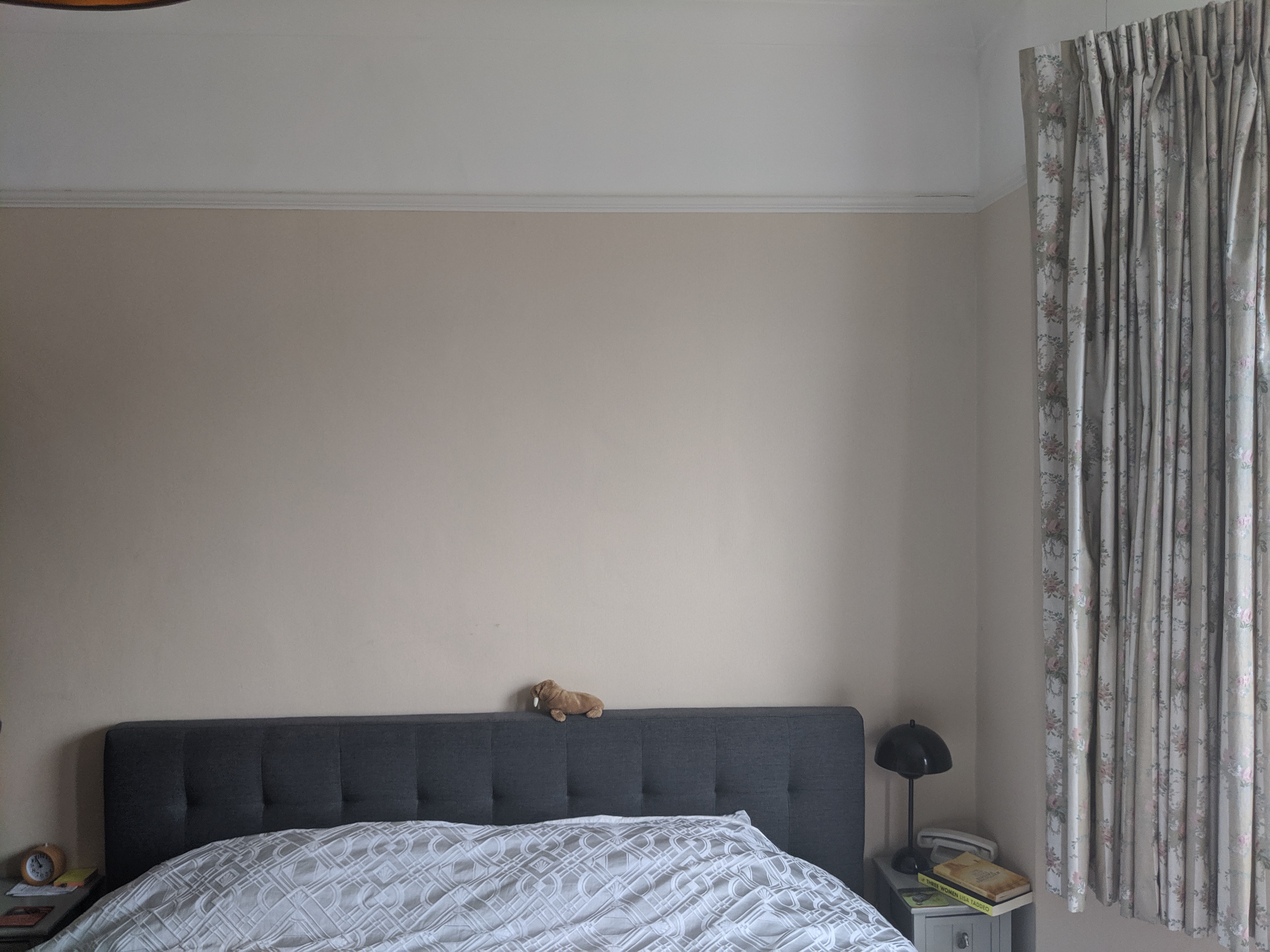 A photo of the room before, showing the bed  against a plain wall.