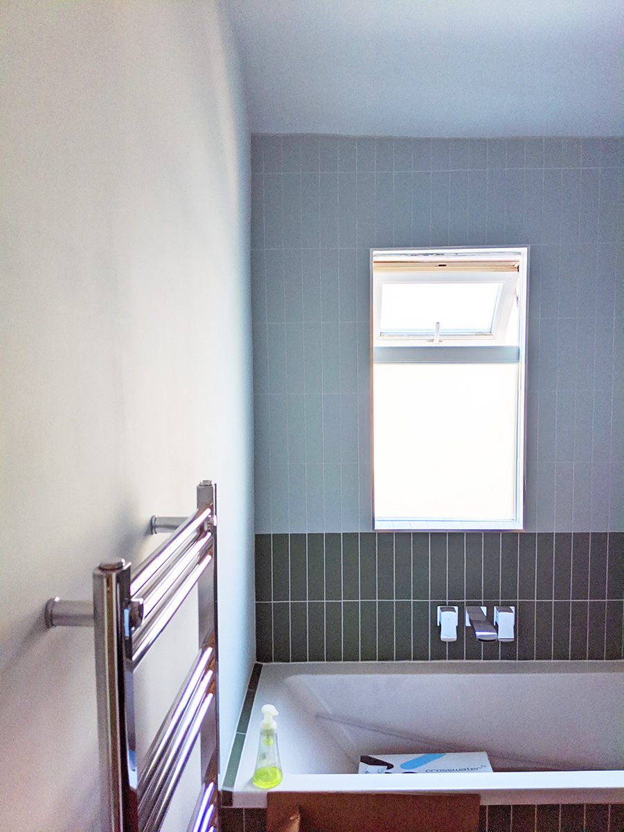A photo of the bathroom with chrome taps and radiator.